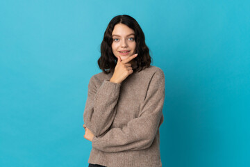 Obraz premium Teenager Ukrainian girl isolated on blue background happy and smiling