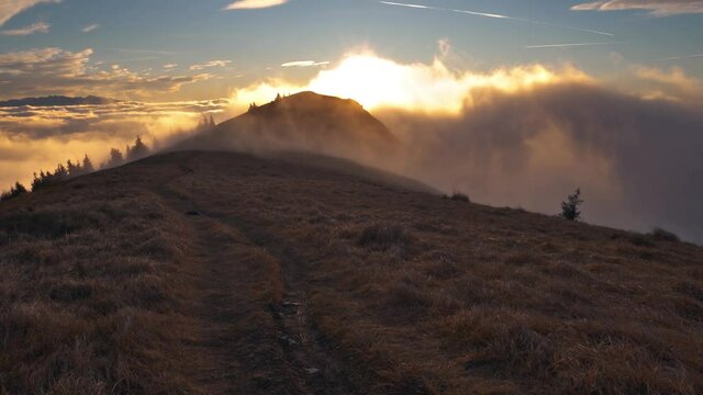 Magic sunny morning nature at sunrise with fast clouds motion over autumn mountain peak Time lapse