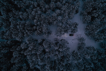 car in the evening forest in winter, top view, copter, aero photo, landscape winter forest