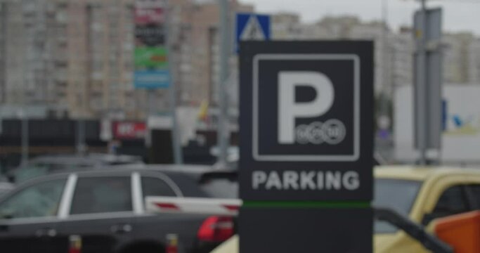 Unfocused shot of parking near the shopping center. Rising and falling barrier allowing cars to pass through