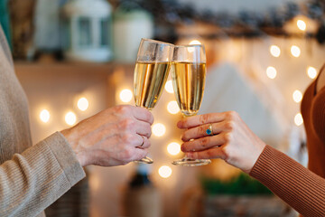 hands couple in love with glasses of champagne in christmas's kitchen. romantic.