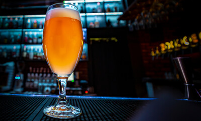 glass of light beer stand on bar counter in a bar or pub