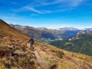 Fototapeta na wymiar Trail for hiking or mountain biking enduro ride at Davos with view of lake of Davos, at autumn time, grison, Switzerland