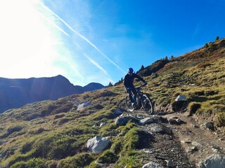 Person rides enduro bike with much action and fun. Davos, Grison, Swiss Alps, Switzerland
