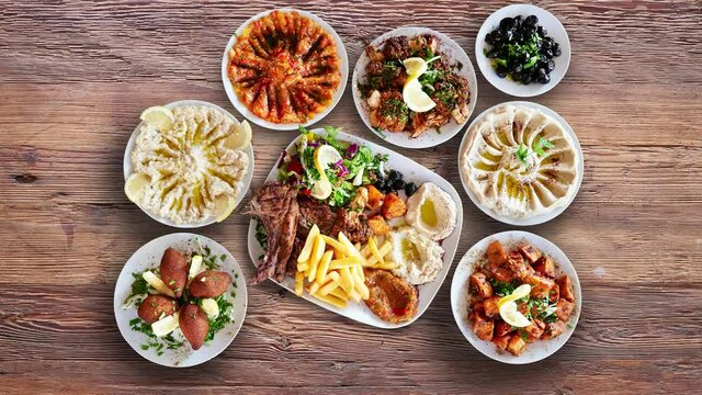 Textured walnut wooden table with Lebanese food animated and view from above