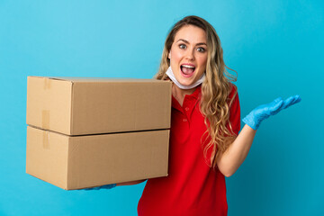 Young delivery woman isolated on white background with shocked facial expression