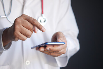 doctor in white coat using a smartphone.
