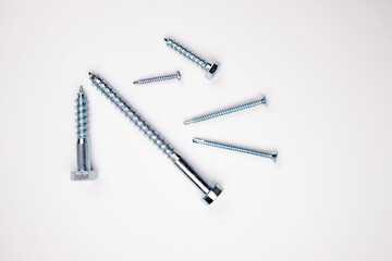 Self-tapping screws and screws of different sizes on a white background.