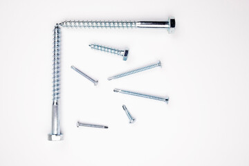 Small self-tapping screws on a white background in the center. Self-tapping frame. Choice of tools