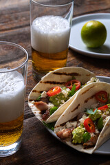 Wheat tortillas with chicken and salsa and glasses of beer