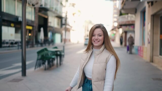 Young blonde woman smiling confident walking at street