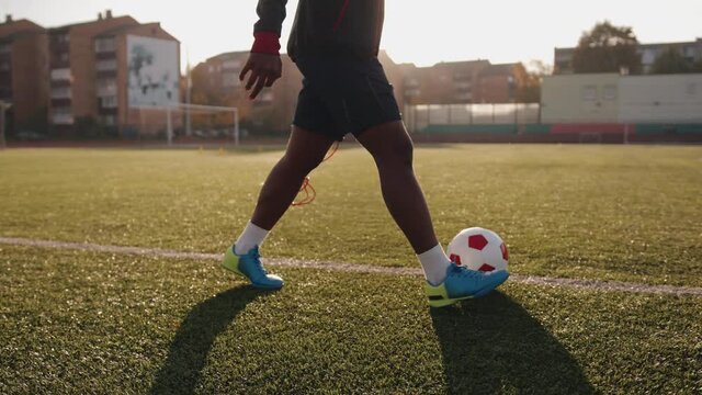 Young black female athlete training on the soccer field and practicing ball possession using dribbling technique