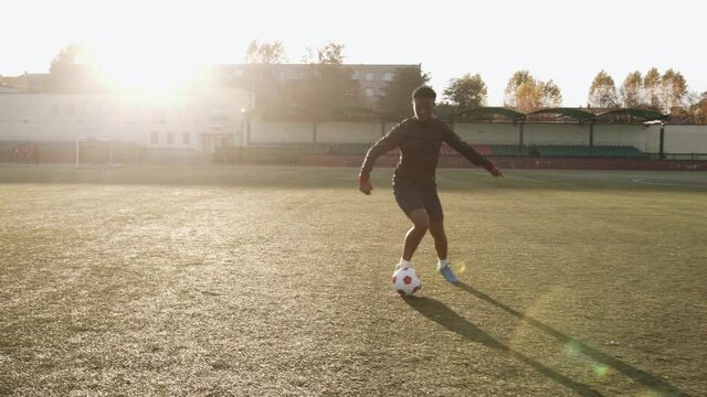 Young black girl in soccer training doing ball handling exercise in motion performing feints and tactical maneuvers