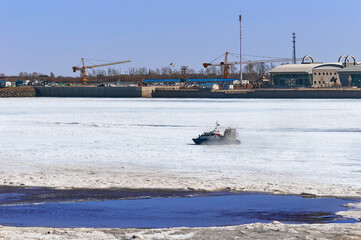 Coast Guard hovercraft on the ice of the Amur River. In the background, China Customs and the...