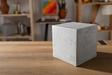 Cement cube in painter artist studio workplace. Paint brush and tools at wood tables