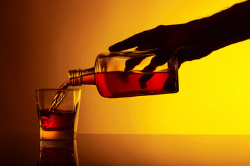 Pouring alcoholic drink from a bottle into a glass.