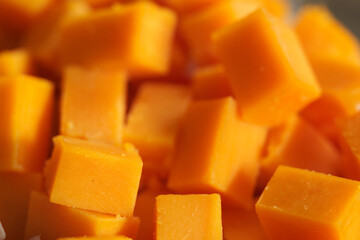 Hard orange cheese cut into cubes.