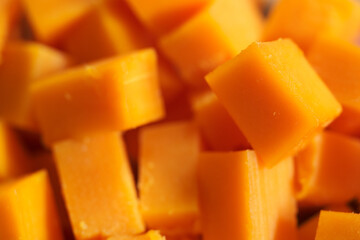 Hard orange cheese cut into cubes.