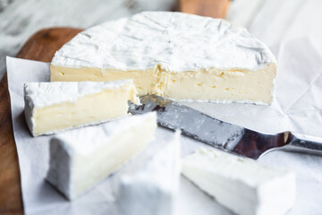 camembert cheese sliced on cutting board