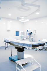Empty operating room in a hospital. Surgical equipment with operating table. Medical device for emergency patient in blue tone style. Blank Emergency Surgery Room. Clinic interior for background.