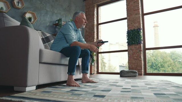 Middle aged man sit couch domestic life watch blockbuster in living room