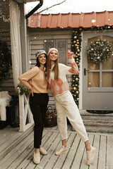 beautiful women with dark hair in cozy clothes posing in decorated Christmas studio - 474367123