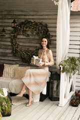 beautiful woman with dark hair in cozy clothes posing in decorated Christmas studio - 474367190
