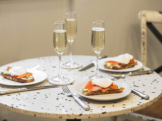 Sunday brunch with prosecco and eggs and salmon bruschetta on marble table
