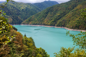 Obraz na płótnie Canvas Сolorful view of the Jvari reservoir with a vibrant turquoise water..Mountain lake formed by the dam on Enguri river. The famouse landmark of Upper Svaneti, Georgia