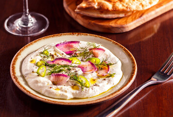  Greek tirokafteri spread with a side order of bread on a wooden table