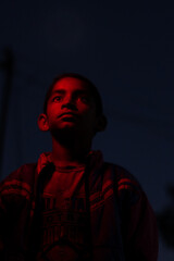cinematic portrait of a young village boy in the dark