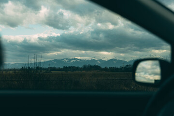 Photo view of mountains from car during cloudy day.