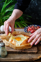 Adjaruli (Acharuli) Khachapuri, Georgian cheese bread. Traditional Georgian recipe made with a bread dough, filled with cheese and crowned with an egg and a butter. 