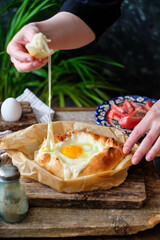 Adjaruli (Acharuli) Khachapuri, Georgian cheese bread. Traditional Georgian recipe made with a bread dough, filled with cheese and crowned with an egg and a butter. 
