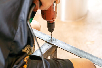 Construction workers use electric drills to drill steel.