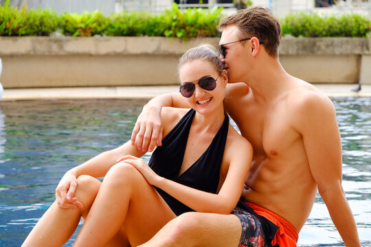 Portrait couple in love, sexy bikini poolside party enjoy having fun in swimming pool