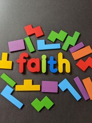 Various colorful shapes with the word faith on a black background