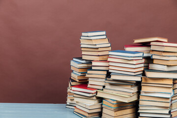 stacks of old books to learn in the library on a brown background