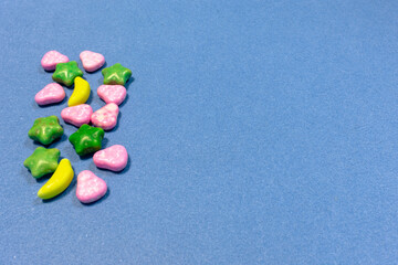 Heap of multicolored tasty candies at the left side of the frame and empty space for your text