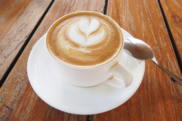 Cup of hot cappucino on the wooden table. Early morning breakfast