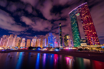 Scenic night view of the skyline of the Dubai Marina district with it's tall skyscrapers raising next to the beach and the waterfront, Dubai, UAE