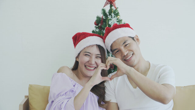 Happy couple in Santa Claus hat sitting Smiling and  selfie