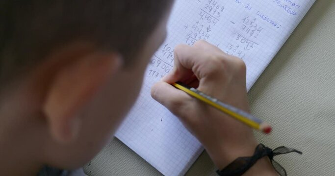 8 year old boy doing his homework at home, no face is shown