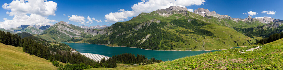 Fototapeta na wymiar Large panorama de montagne avec ligne de crête dont la Pierra Menta et lac de barrage, Beaufortain Savoie France
