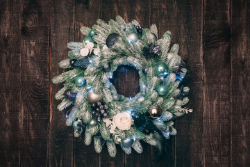 Handmade Christmas artificial wreath on a wooden door. Home decoration for winter holidays