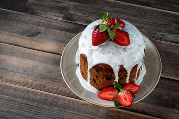 Easter cake with strawberries on a wooden background.