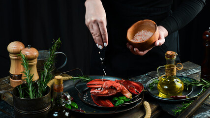 Seafood. Lobster claws on a plate in the hands of the chef. Food banner.