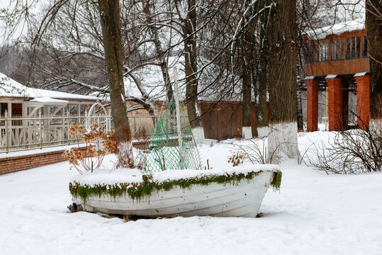 Landscaping. Rowing boat in the form of a flower bed with flowers on a winter snowy day