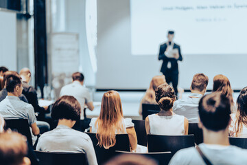 Business speaker giving a talk at business conference event.