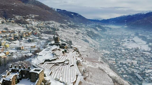Aerial 4K, Castel Grumello and vineyards, near Sondrio in Valtellina, winter view	